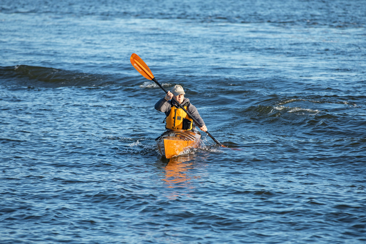 A man paddling a Chesapeake 17 wooden kayak