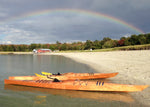 A pair of Chesapeake 17 wooden kayaks built by Mike D. under a rainbow on a beach in Portland, ME Thumbnail