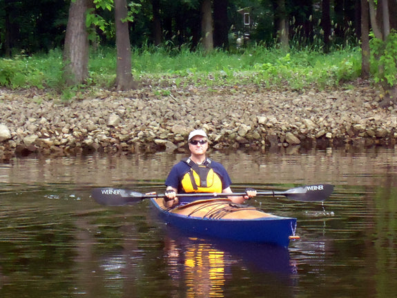 A man paddling a Chesapeake 18 wooden kayak built by Chris P.