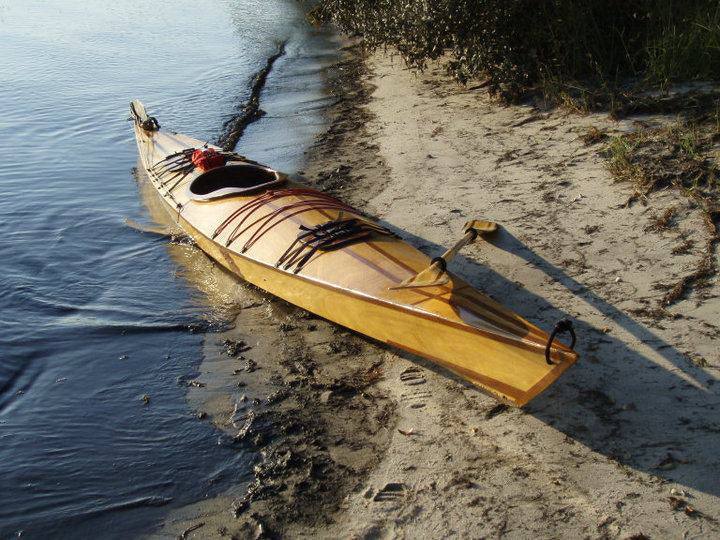 A Chesapeake 18 wooden kayak with dark strip accents built by Jeff W. in North Carolina
