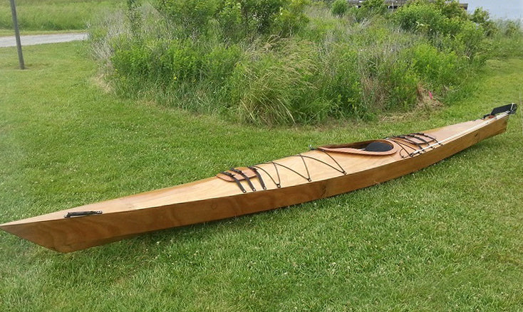 A Chesapeake 18 wooden kayak built by John O. on a lawn at Backbay National Wildlife Refuge in Virginia