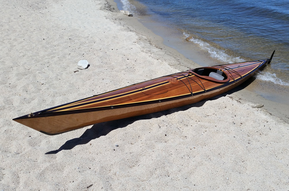 Mike J's hybrid Chesapeake 18 wooden kayak pulled up on a beach