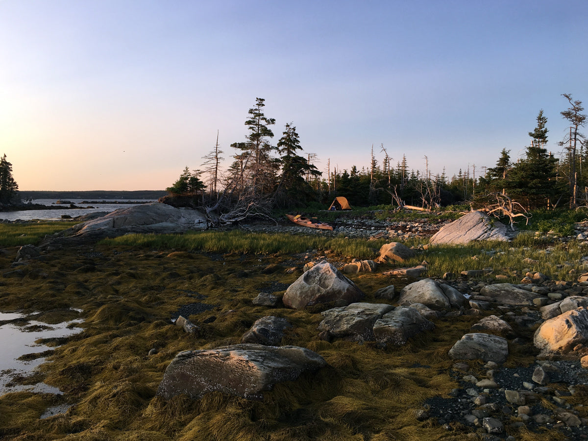 A Chesapeake Double wooden kayak built by Doug F. beached at a campsite at low tide in Nova Scotia.