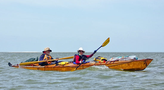 A couple paddling a fully loaded Chesapeake Double wooden kayak built by William R.