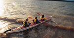Three paddlers setting off from shore in a Chesapeake Triple wooden kayak Thumbnail