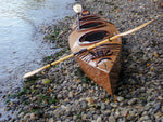 A Chesapeake Triple wooden kayak built by Jonathan M on a stony beach Thumbnail