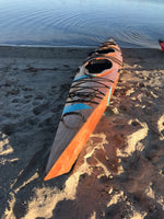A beached Chesapeake Triple wooden kayak built by Mariana B. Thumbnail