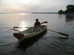 The sun is setting as a woman rows her Chester Yawl on the Ottawa River. Thumbnail
