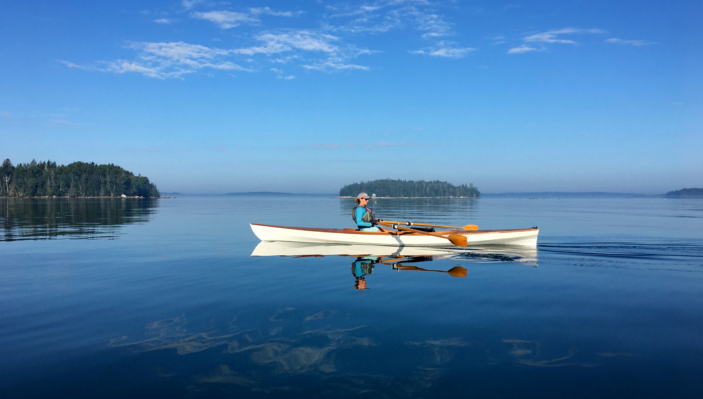 Christine Y. enjoying a quiet row in her Expedition Wherry on a glassy sea in Brooklin, Maine.