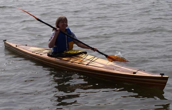A woman paddling a Great Auk 17 sea kayak by Tom S.