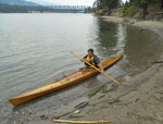 A handsome Great Auk 17 sea kayak built by Alfred C., paddled along a beach Thumbnail