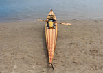 A creatively strip planked Guillemot Single wooden kayak on the shore at Newport Beach, CA Thumbnail