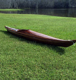 A Guillemot Single wooden kayak built by Ben I. on a waterside lawn Thumbnail