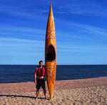 Christopher M. with his Guillemot Single wooden kayak at the beach Thumbnail