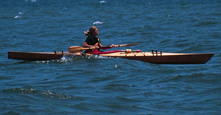 A woman paddling a Chesapeake 16LT wooden kayak