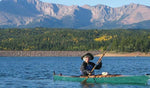 A woman paddling a Chesapeake 16LT wooden kayak on a mountain lake Thumbnail