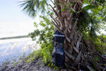 mesh trash bag hung from palm tree Thumbnail