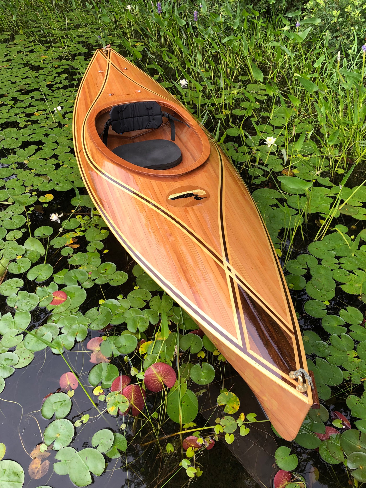 A Wood Duck 10 Hybrid kayak with delicate stripping pattern on the deck built by Jim R.
