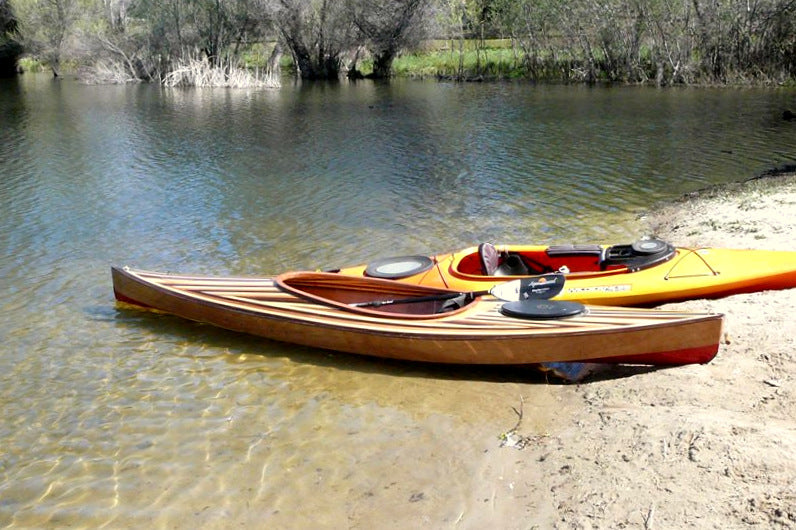 This Wood Duck 14 Hybrid kayak stands out next to its yellow neighbor on the water's edge