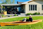 Builder Dave L's wife and dog trying out the fit of his Wood Duck 14 Hybrid kayak on their lawn. Thumbnail