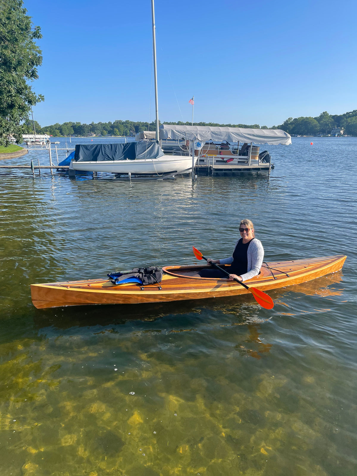 A woman paddling a Wood Duck 14 Hybrid kayak on Lake George in Indiana. Built by Mark G.