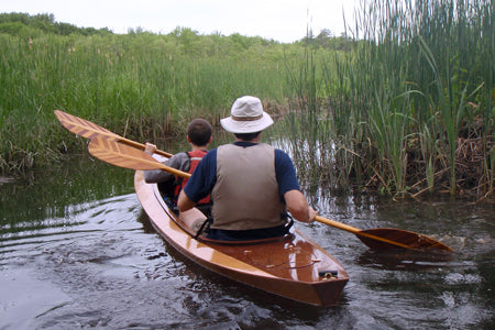 Man and boy exploring a marsh in their Wood Duck Double kayak.