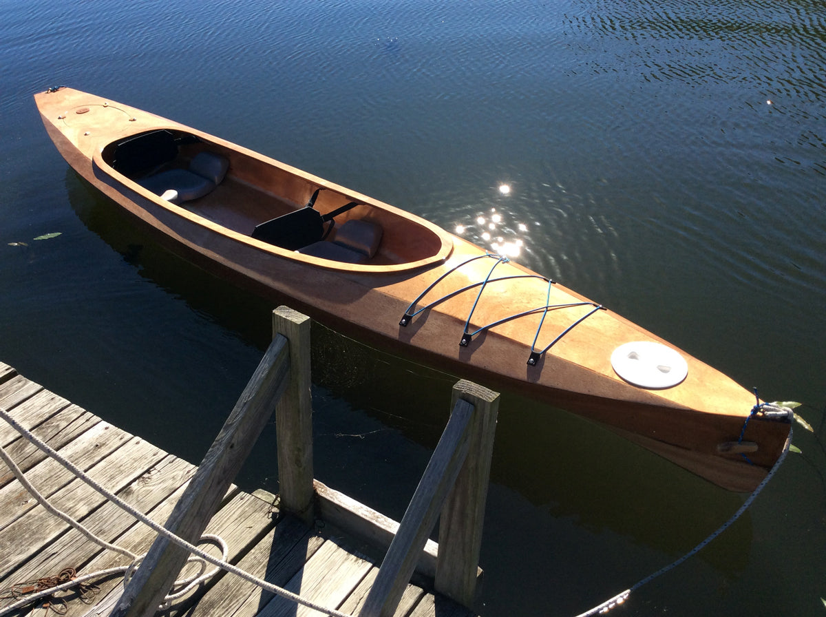 A Wood Duck Double kayak built by Chuck J. floating at the dock