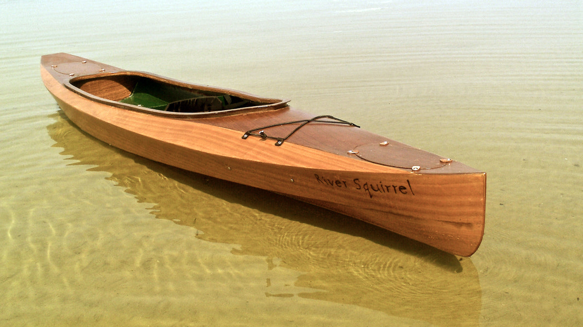 RIVER SQUIRREL, a Wood Duck Double kayak built by Travis H., waits in the shallows on Green Lake in Michigan.