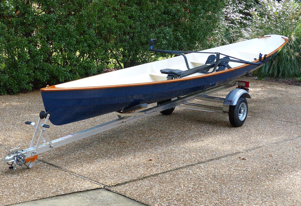 A dark blue Annapolis Wherry with white interior built by John R., on a trailer in Richmond, VA