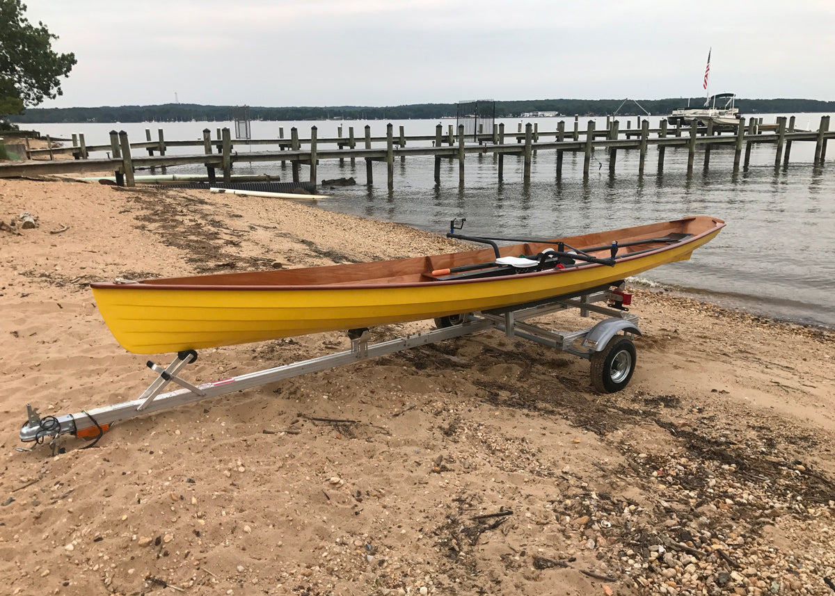 A yellow Annapolis Wherry on a Trailex trailer at the beach