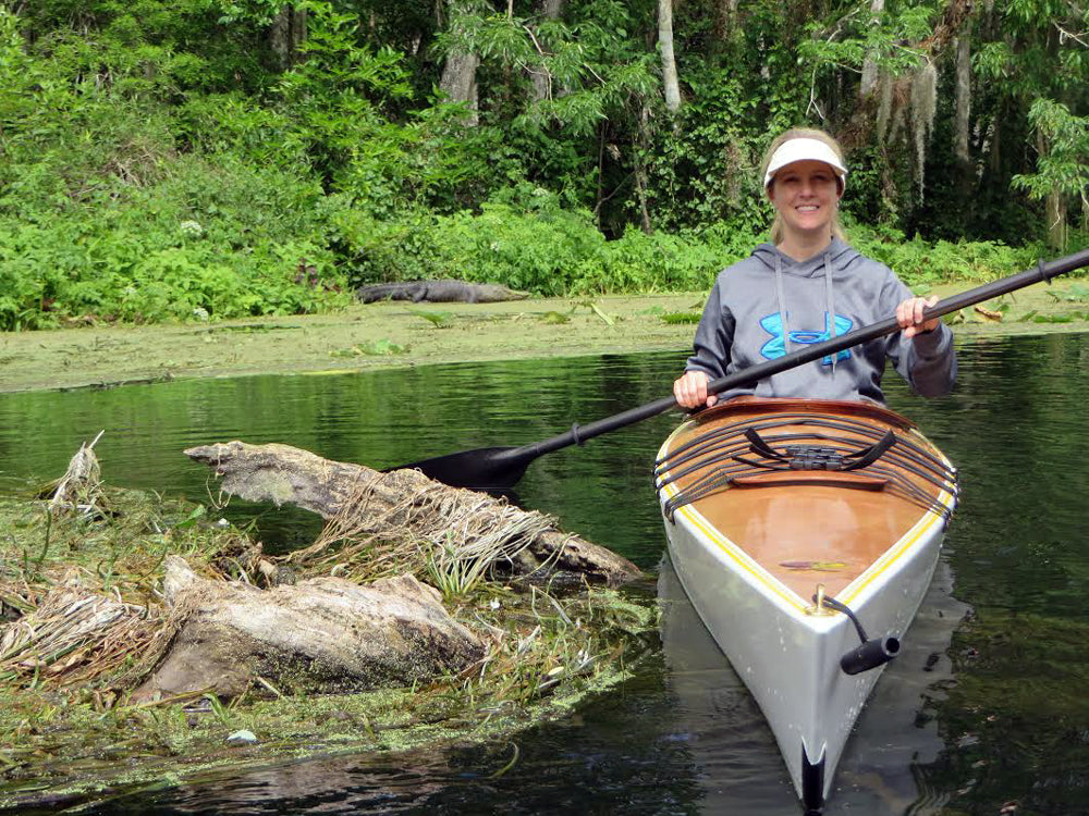 A woman paddling a Chesapeake 16LT wooden kayak built by Mark N. in the Silver River in Central Florida 
