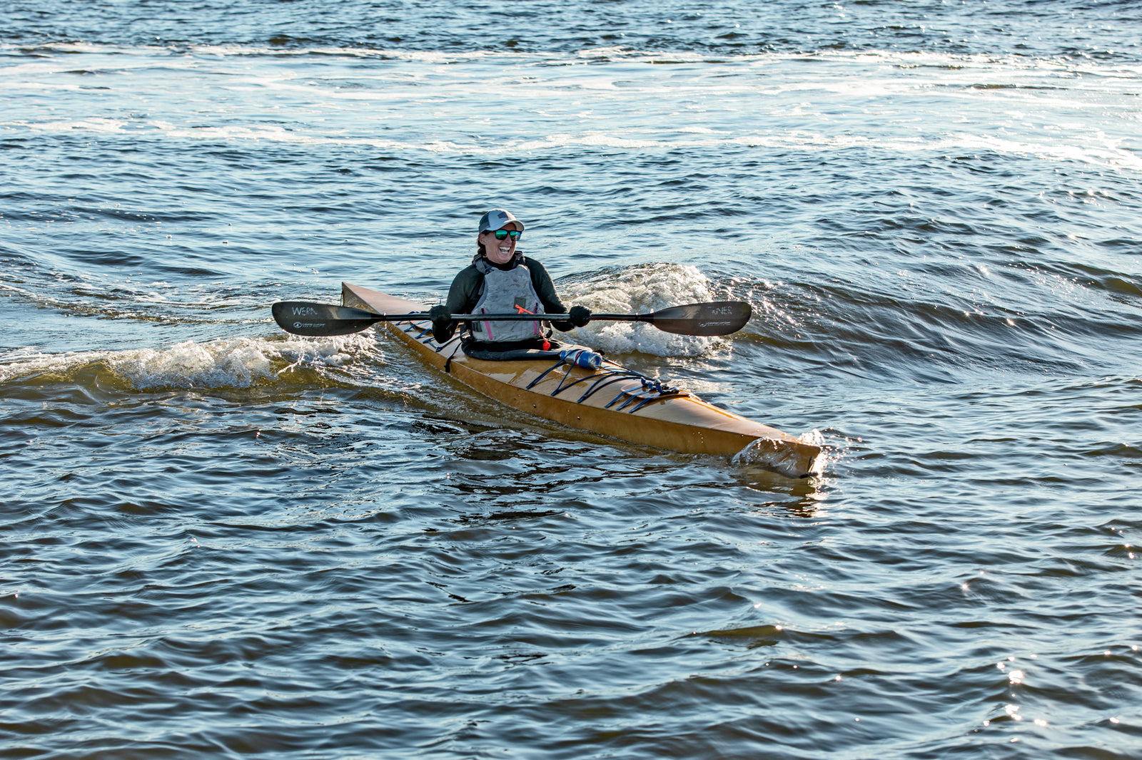 A woman enjoying a day on the waves with a Chesapeake 16LT wooden kayak