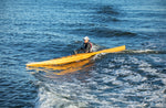 A woman paddling a Chesapeake 16LT wooden kayak down a wave Thumbnail