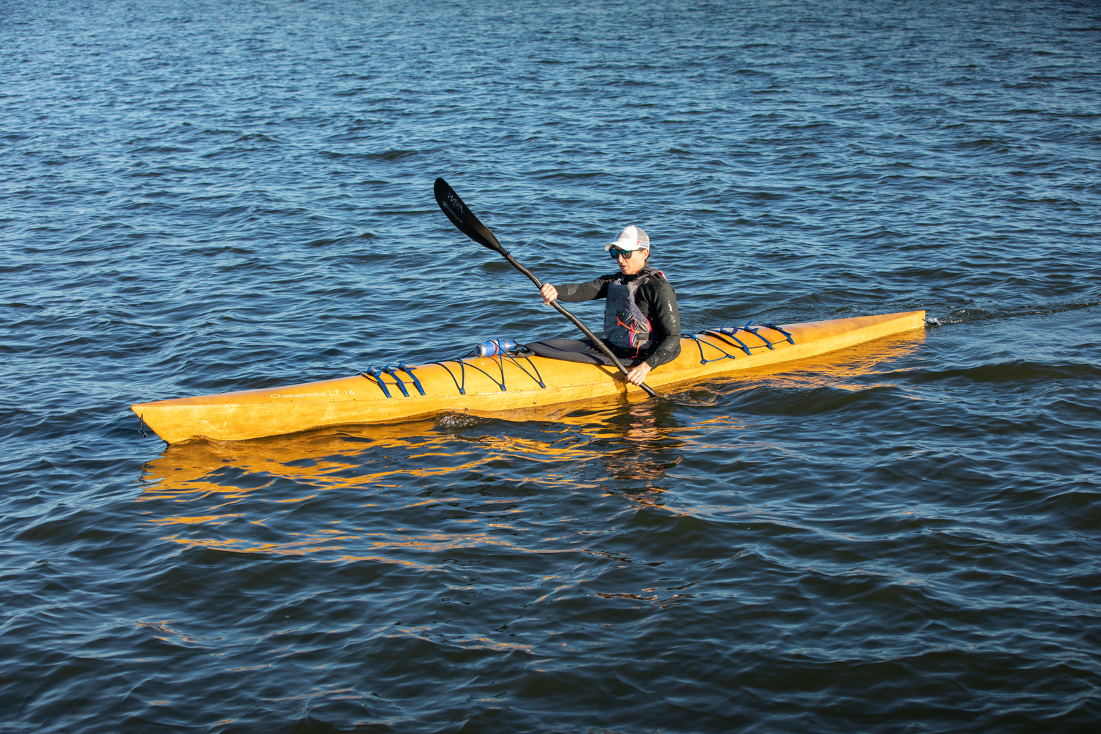 A woman paddling a Chesapeake 16LT wooden kayak