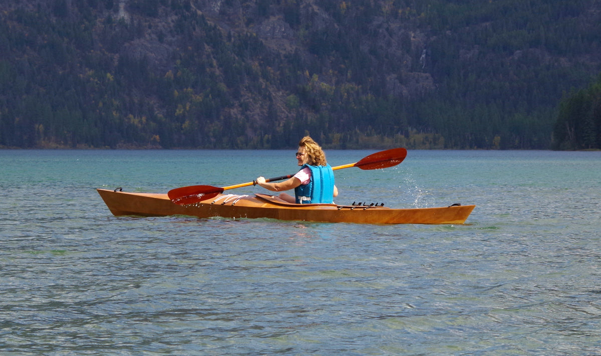 A woman paddling a Chesapeake 14 wooden kayak built by David S.
