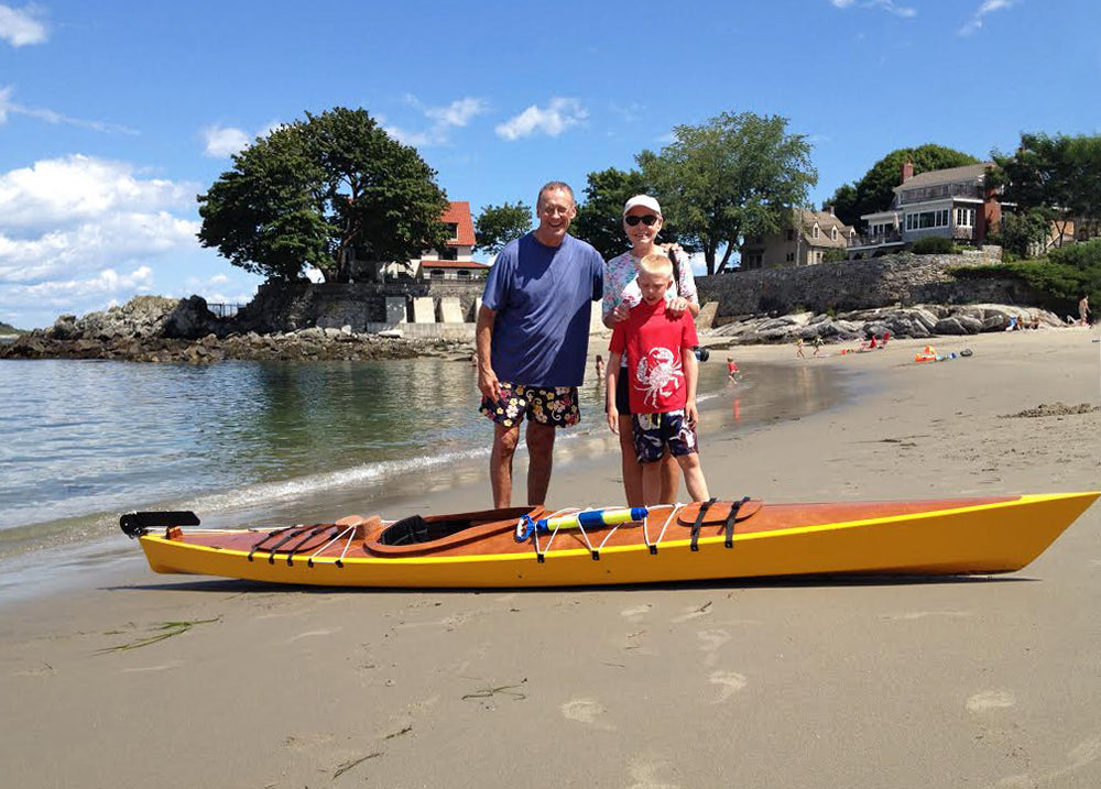 Tony O. and his family with the Chesapeake 14 wooden kayak he built at Cape Elizabeth, Maine