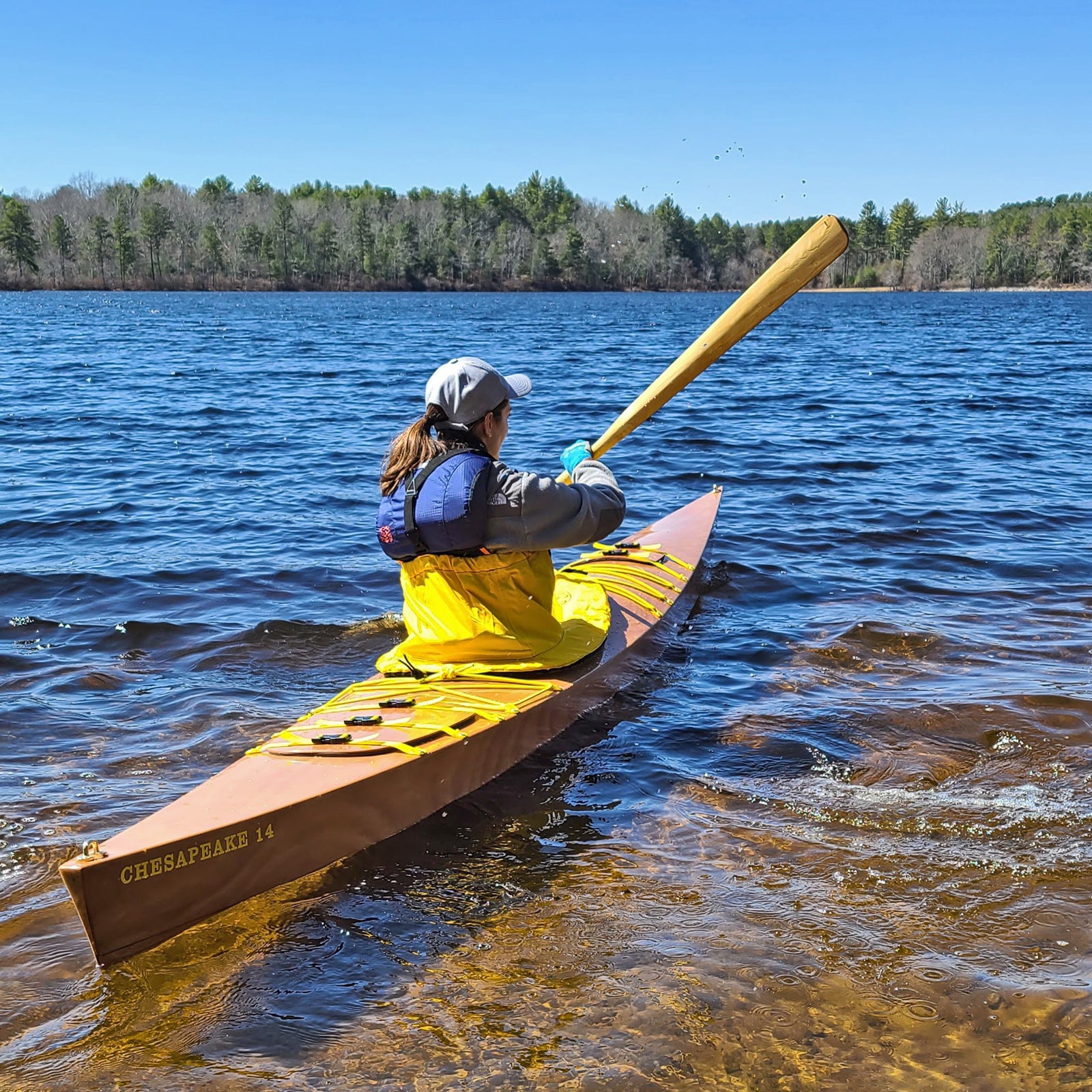 A woman paddling a Chesapeake 14 wooden kayak by William S.