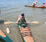 A young paddler coming ashore with a Chesapeake 14 wooden kayak Thumbnail