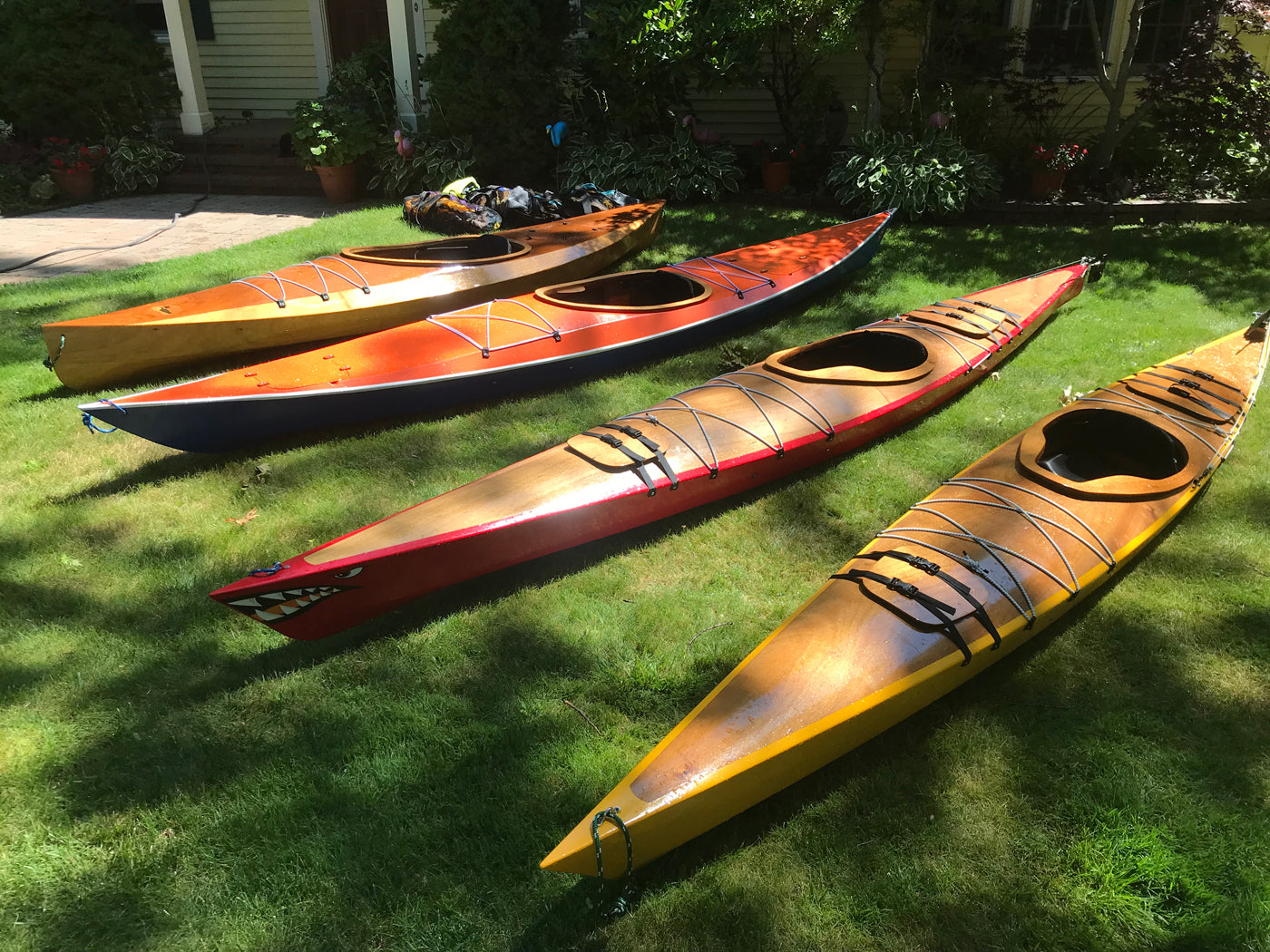 A lineup of wooden kayaks by Tony O., Cape Elizabeth, ME: Wood Duck 14, Shearwater Sport, Chesapeake 14, and Chesapeake 16LT (left to right)