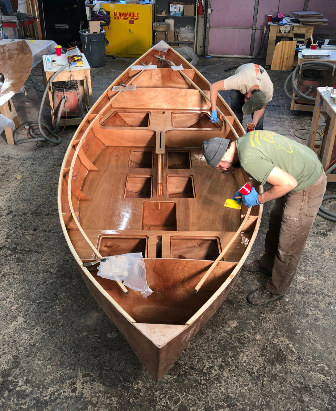 Two builders working on a Guider are cleaning fillets in the cockpit.