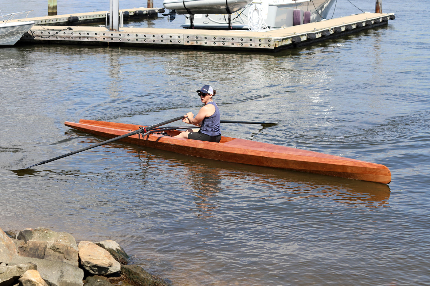 Person rowing the Surge Coastal Rower near a dock.