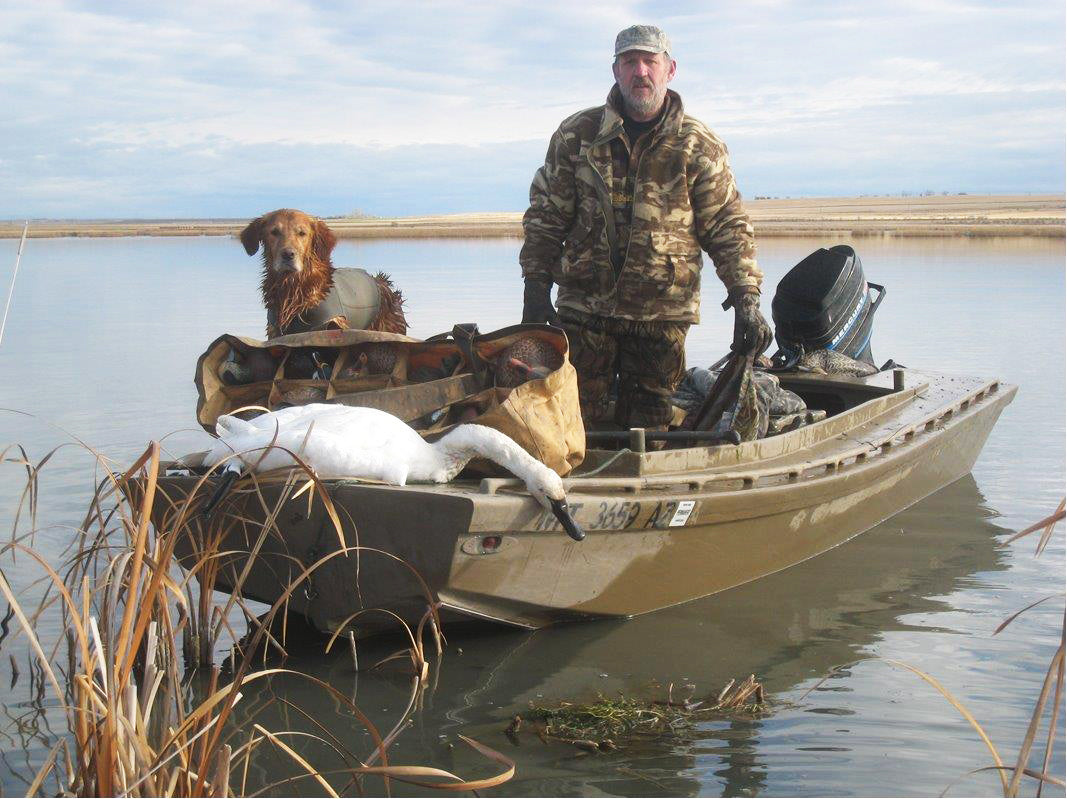After a day spent hunting in his Cackler, 14, this hunter returns with his dog, decoys, and a dead swan.