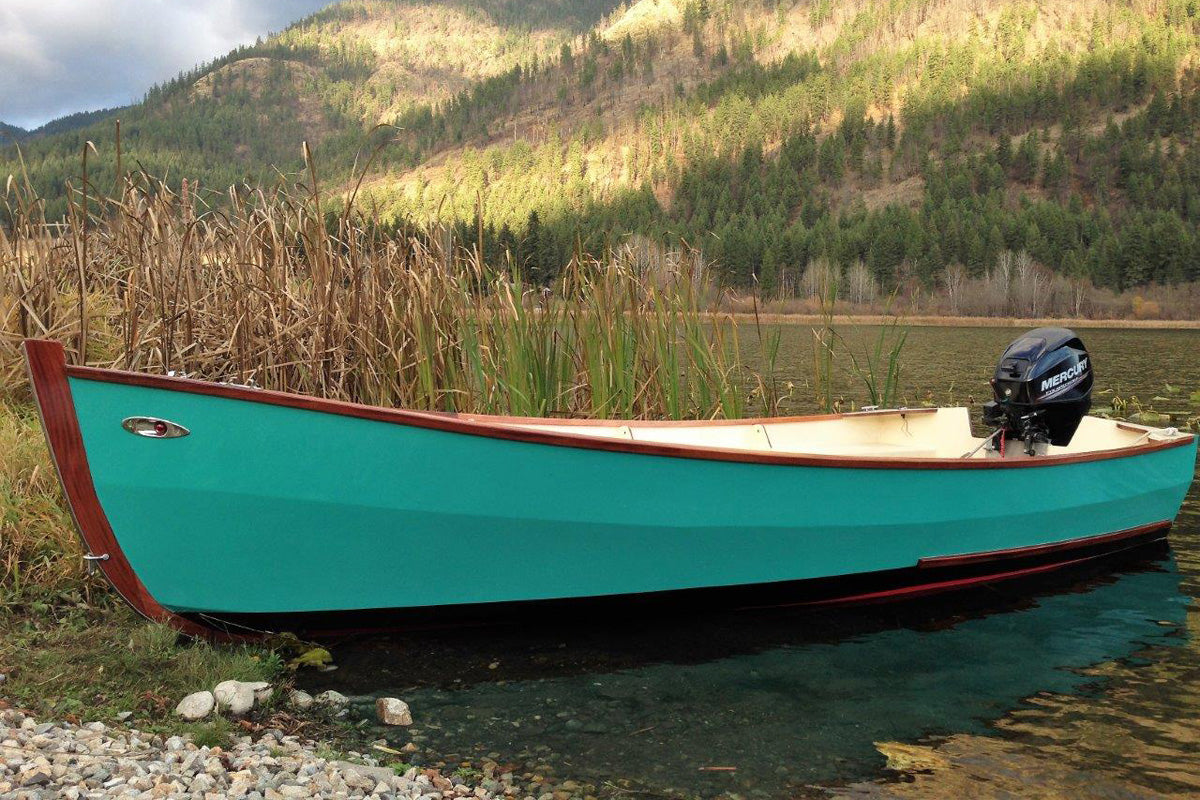 A green Candlefish 16 pulled up to the shoreline.