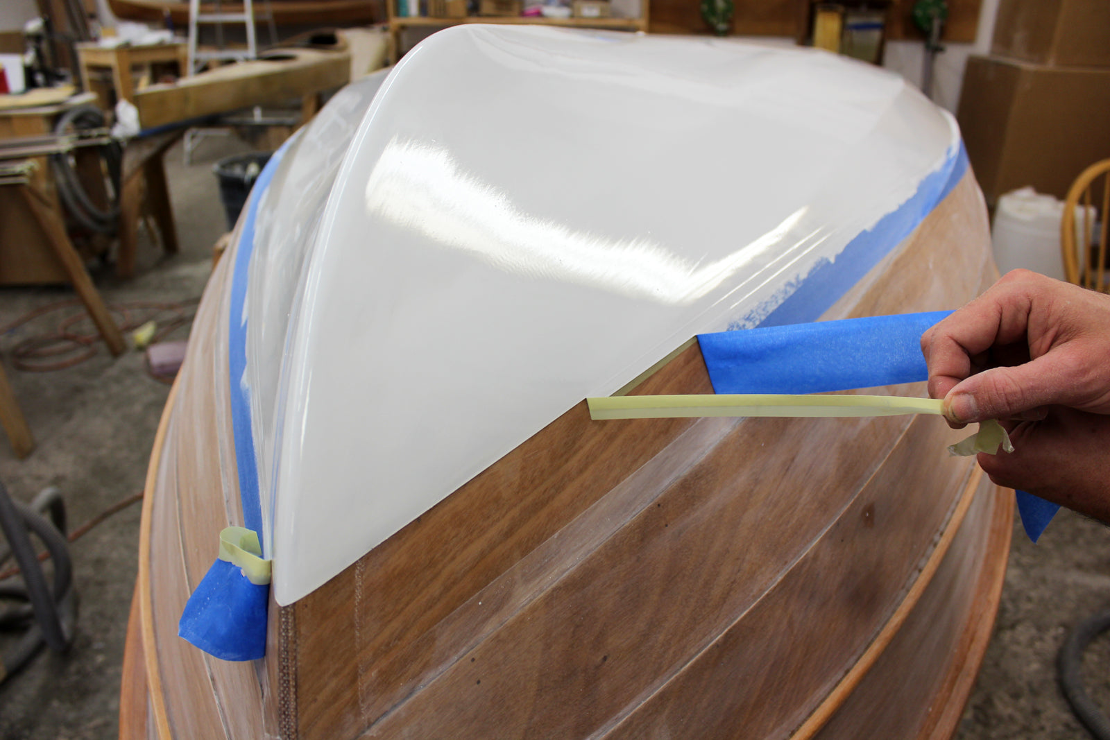Fine line tape being used when painting the Tenderly hull.