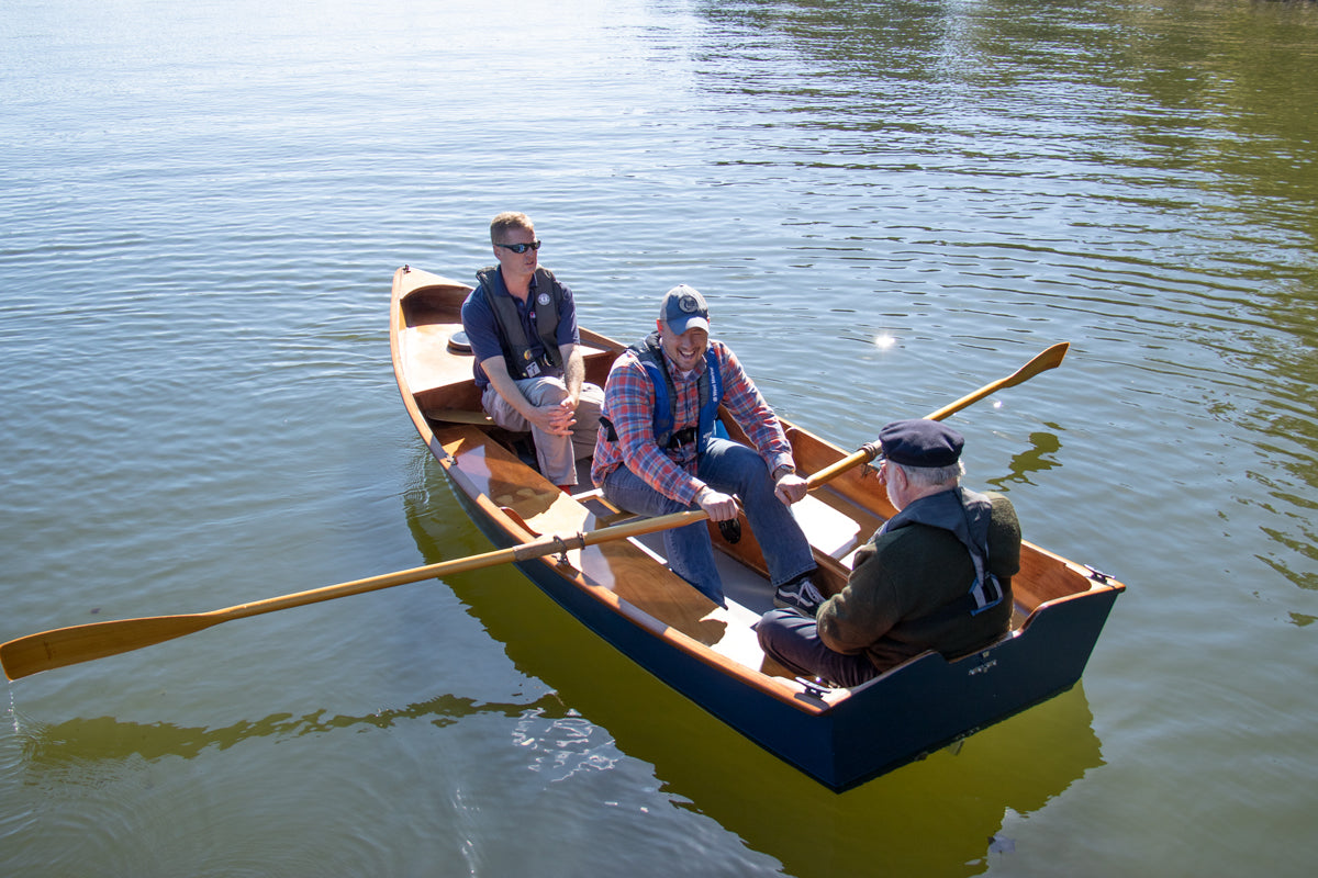 Jimmy Skiff with 3 men rowing from the center seat. 