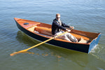 John Harris, CEO of Chesapeake Light Craft, showing off his rowing skills in his Jimmy Skiff II. His ultra-cool sunglasses and confident rowing posture augment the boat's beauty.  Thumbnail