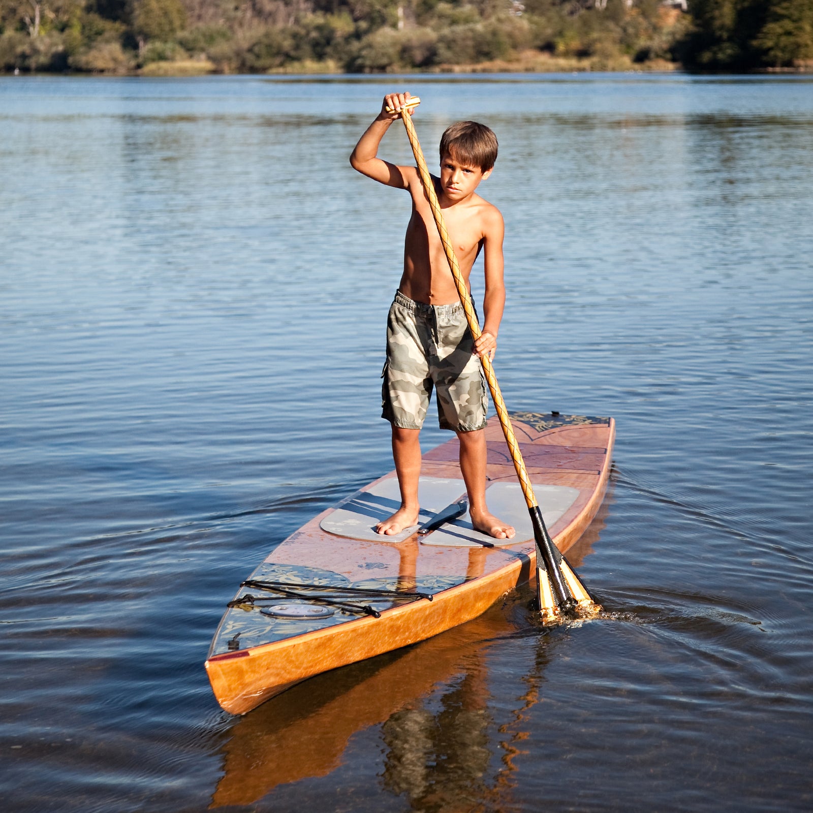 This boy is concentrating as he moves his Kaholo 12-6  paddleboard gracefully through the water.