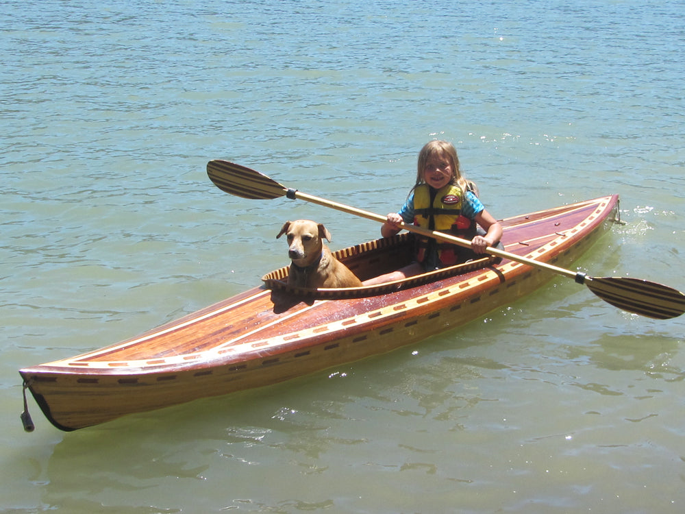 A young girl and her dog paddling a Little Auk 10 by Tom B.