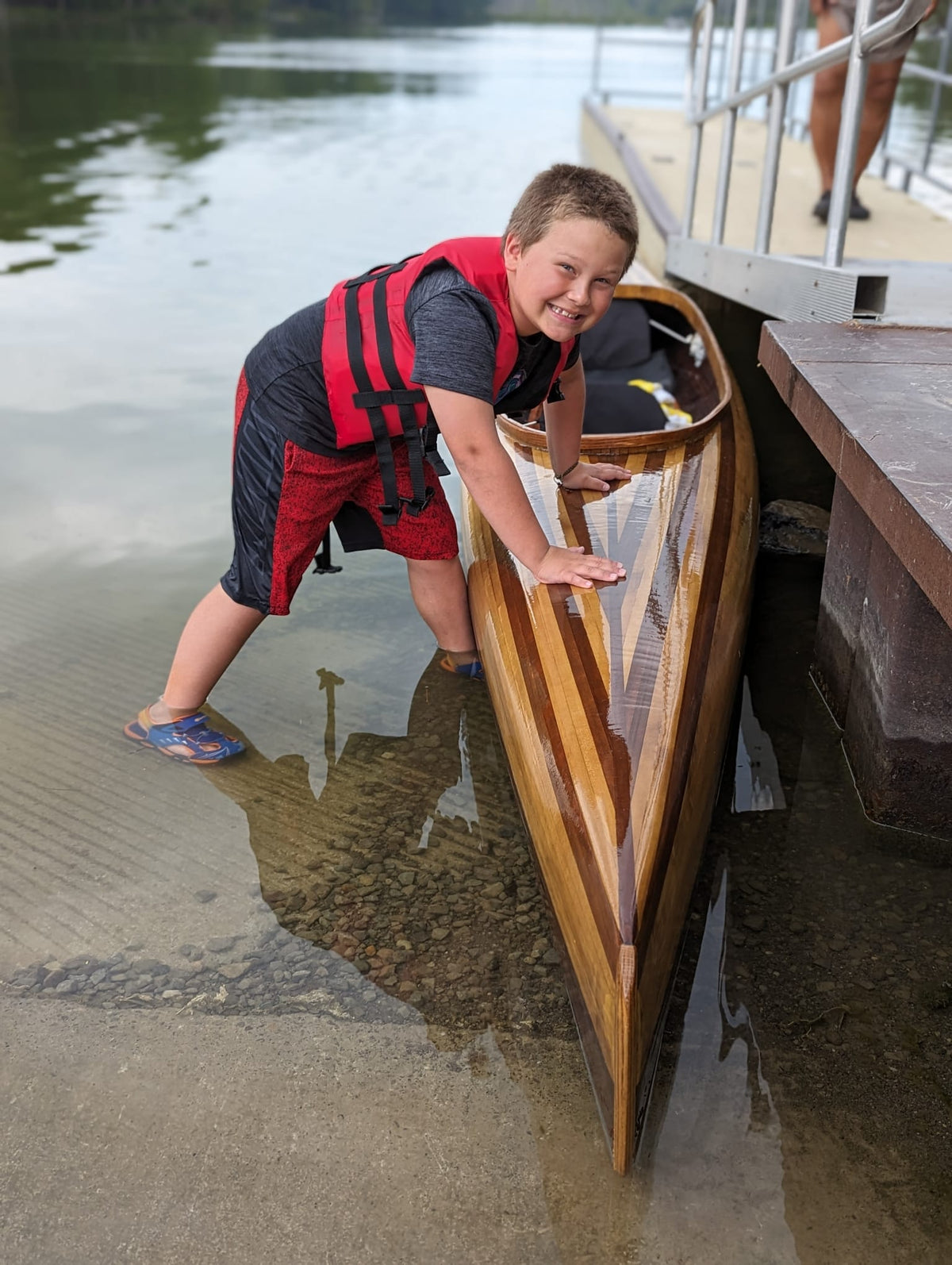 A young paddler waiting for a ride in this microBootlegger Tandem wooden kayak built by Matthew G.