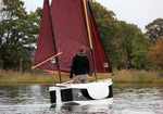The designer, John Harris, stands in the stable Nesting Expedition Dinghy as it ghosts along the Wye River in Maryland. Thumbnail